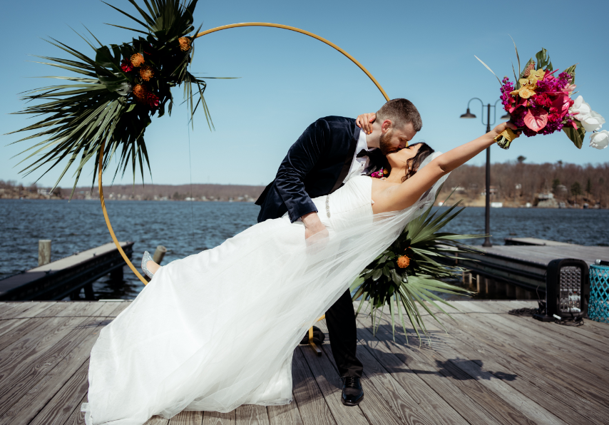 Groom kissing bride on dock