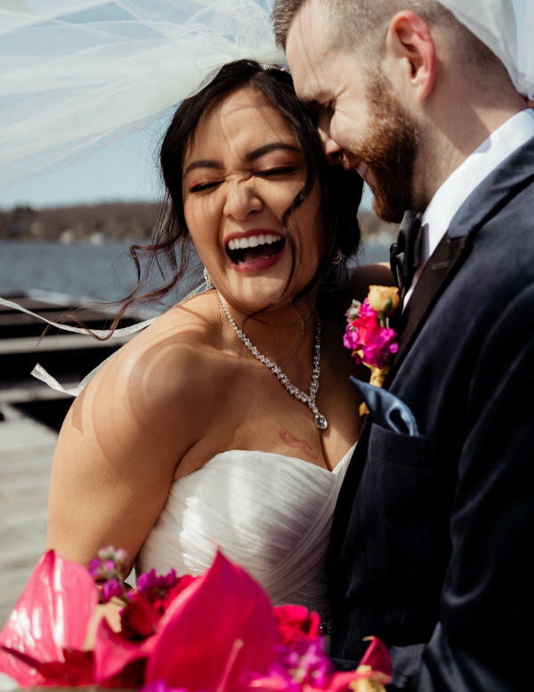 Bride and groom laughing on dock 